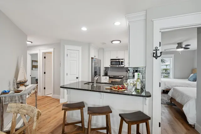 a kitchen with stainless steel appliances kitchen island granite countertop a table and chairs