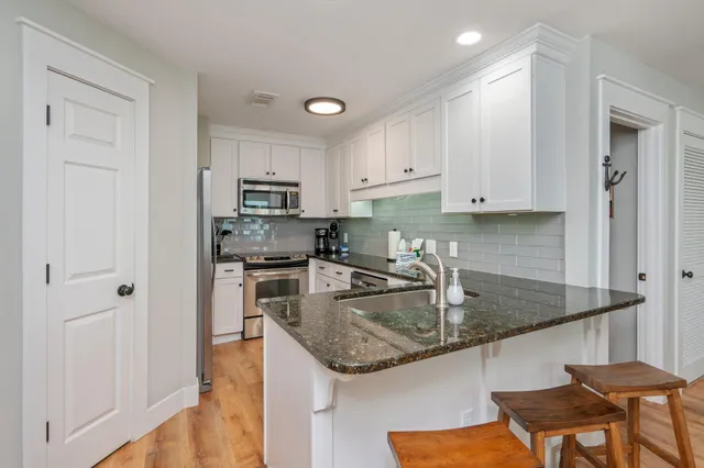 a kitchen with stainless steel appliances granite countertop a sink stove and refrigerator