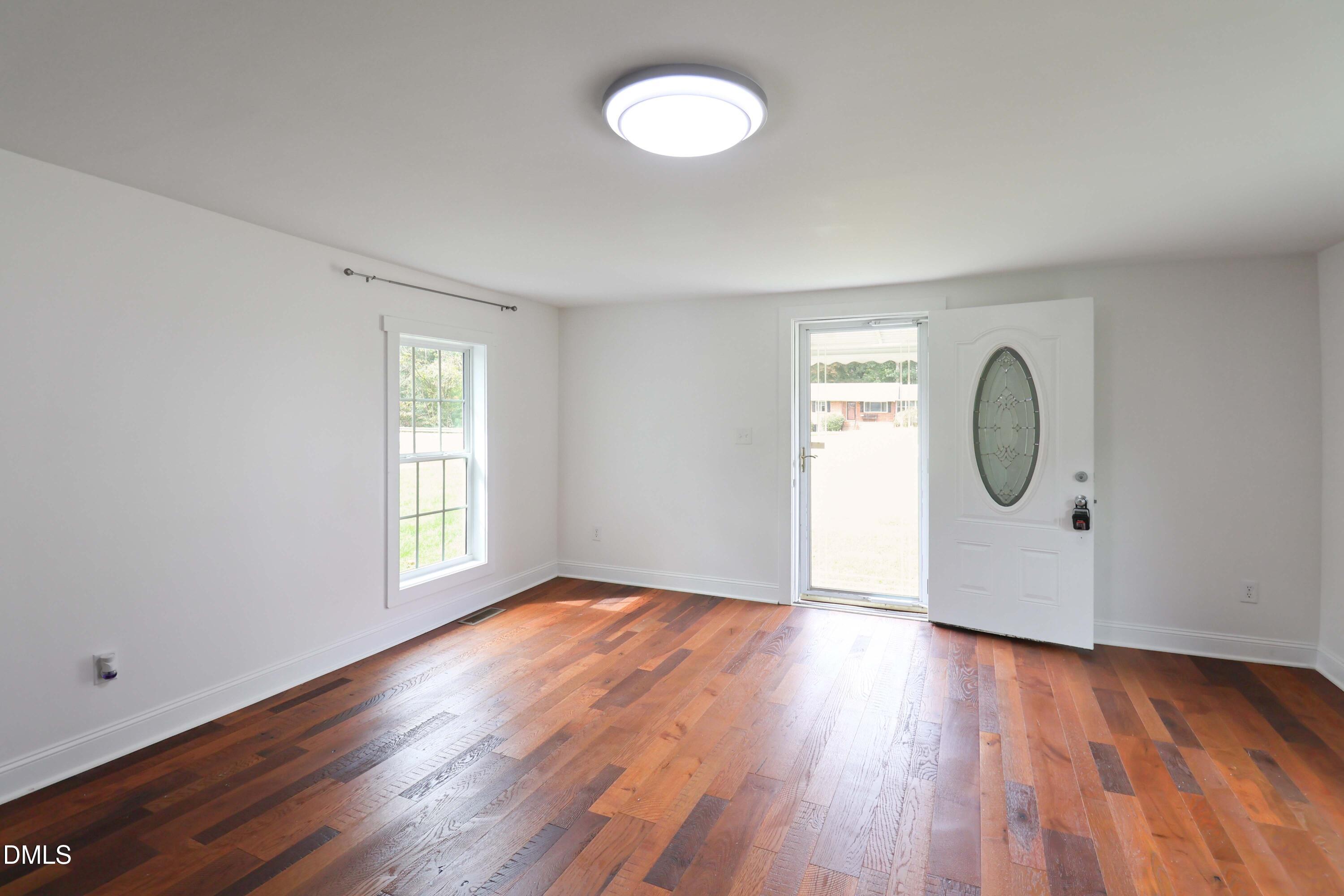 5209 Durham Road Raleigh, NC 27613 - Photo 3 of 18 a view of a room with wooden floor and window