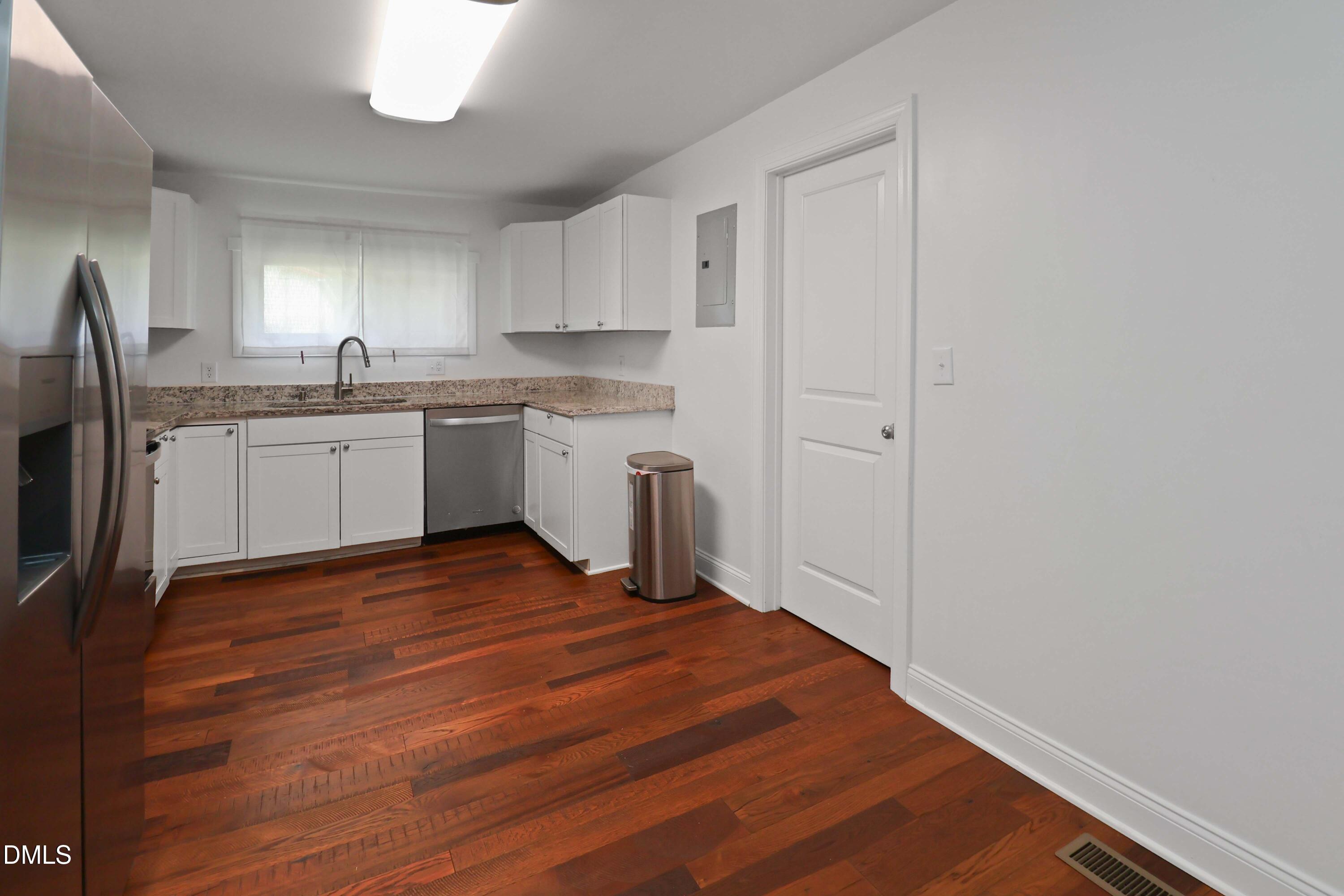 5209 Durham Road Raleigh, NC 27613 - Photo 5 of 18 a kitchen with granite countertop white cabinets and white appliances