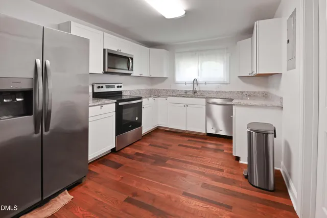 a kitchen with granite countertop a refrigerator stove and microwave