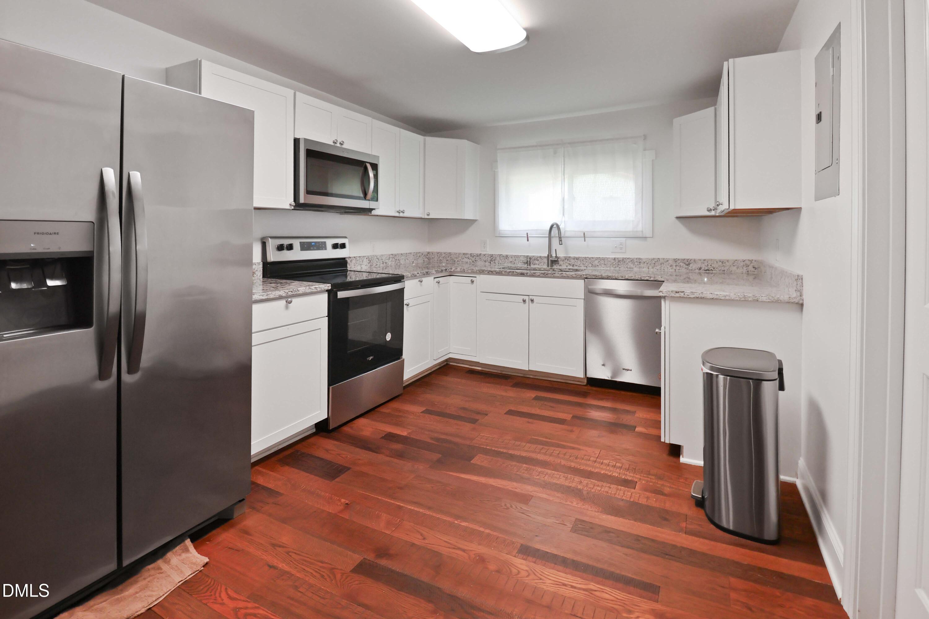 5209 Durham Road Raleigh, NC 27613 - Photo 6 of 18 a kitchen with granite countertop a refrigerator stove and microwave