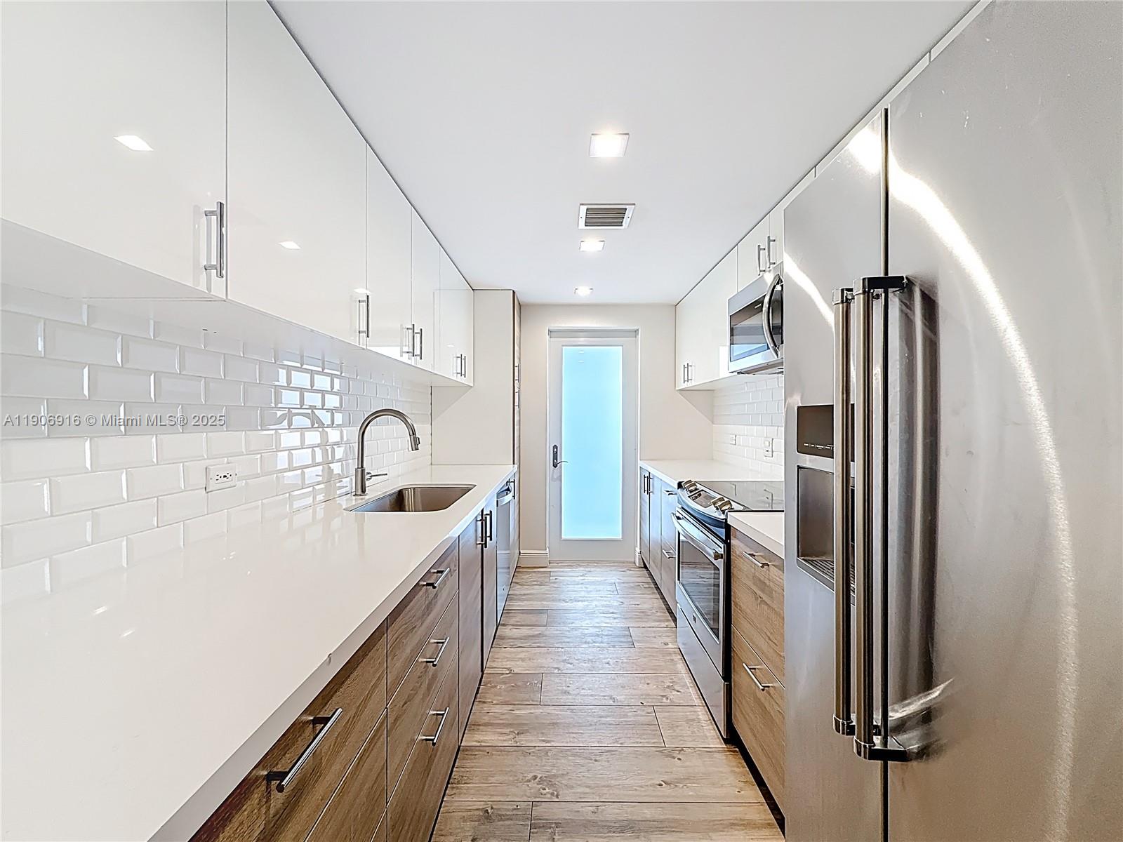 Key Biscayne Key Biscayne, FL 33149 - Photo 13 of 30 a kitchen with white cabinets and stainless steel appliances