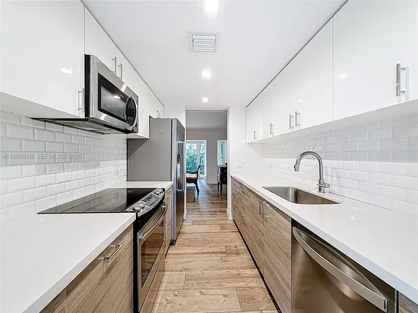 a kitchen with a sink and stainless steel appliances