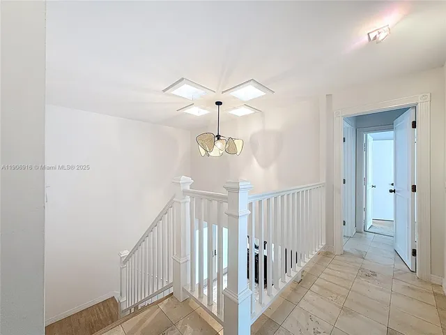 a view of a hallway with a chandelier fan