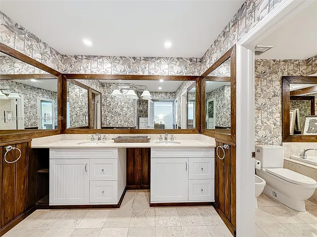 a bathroom with a sink a toilet and a large mirror