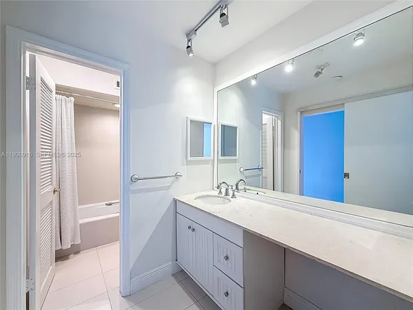 a bathroom with a double vanity sink mirror and bathtub
