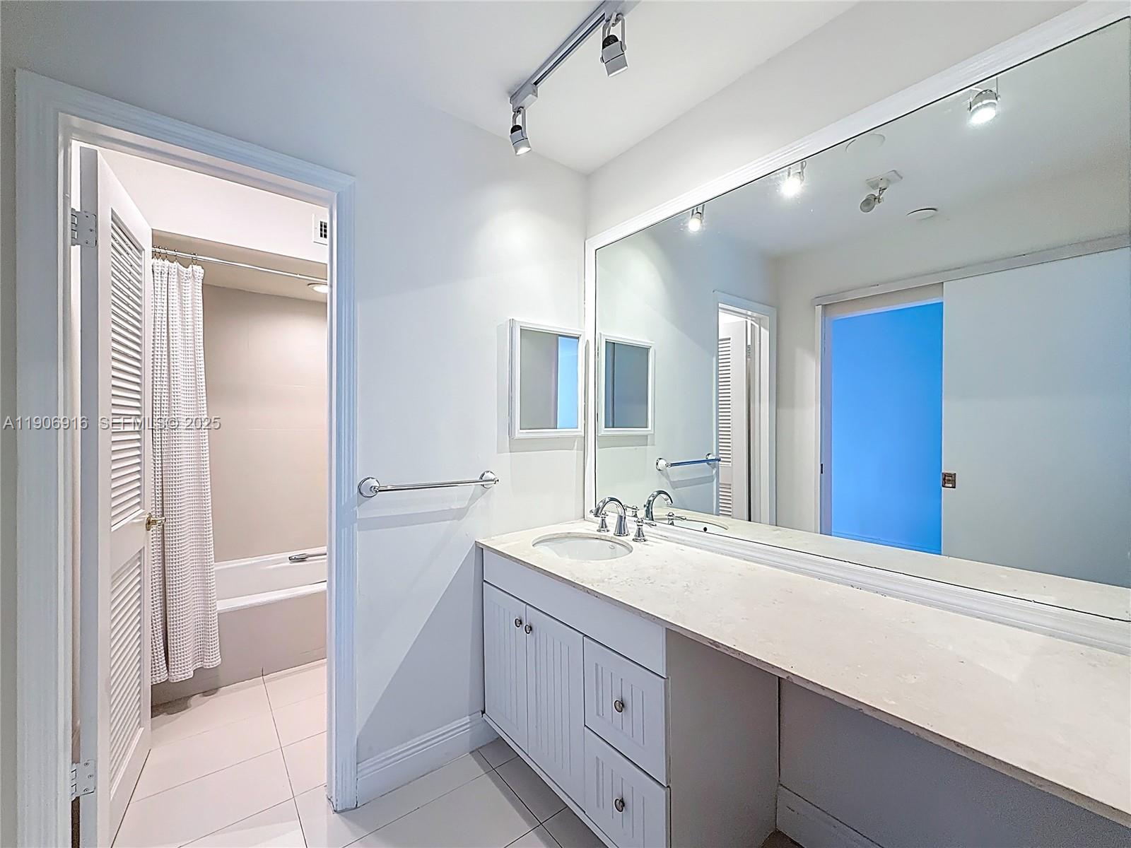 254 Seaview Drive, Unit 5 Key Biscayne, FL 33149 - Photo 25 of 30 a bathroom with a double vanity sink mirror and bathtub