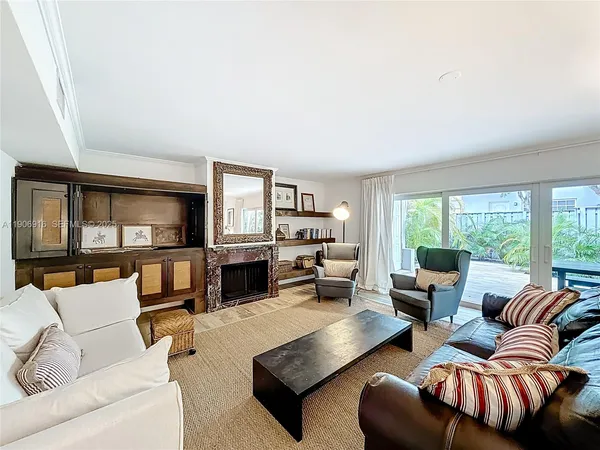 a living room with furniture fireplace and a large window