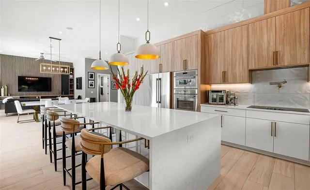 a view of a patio with couches chairs potted plants and floor to ceiling window