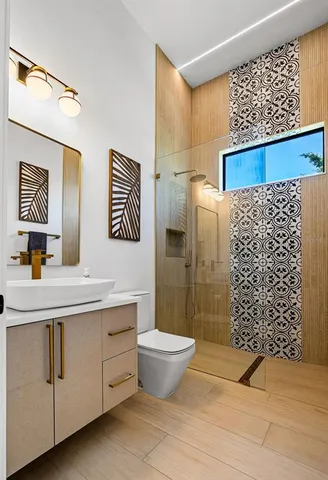 a bathroom with a sink a toilet and shower