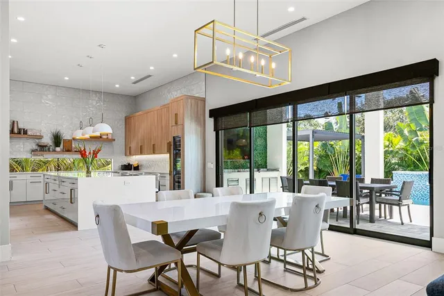 a dining room with furniture a chandelier and wooden floor