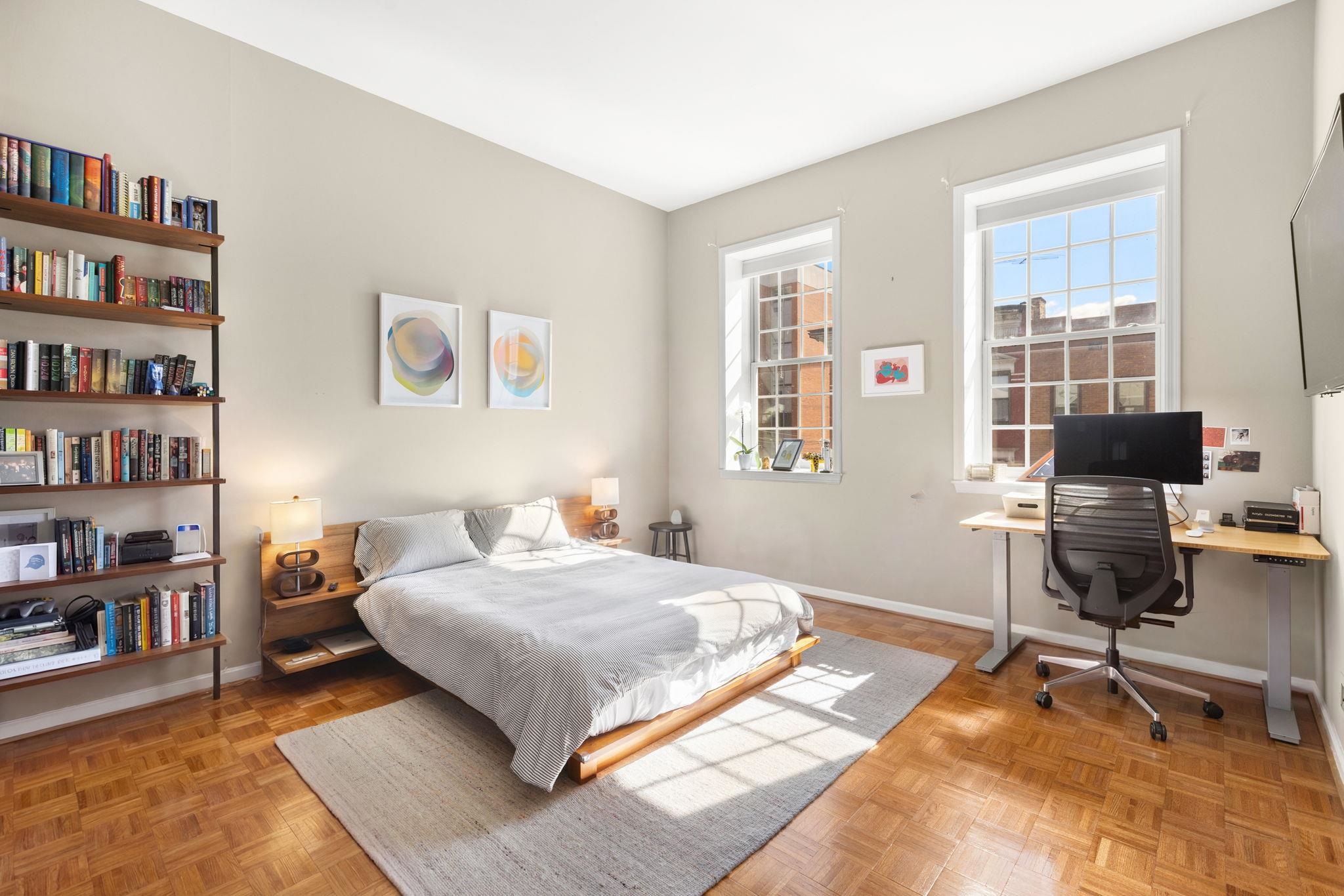 222 Clinton Street, Unit 13 Hoboken, NJ 07030 - Photo 4 of 16 a bedroom with a bed a bookshelf and a bookshelf