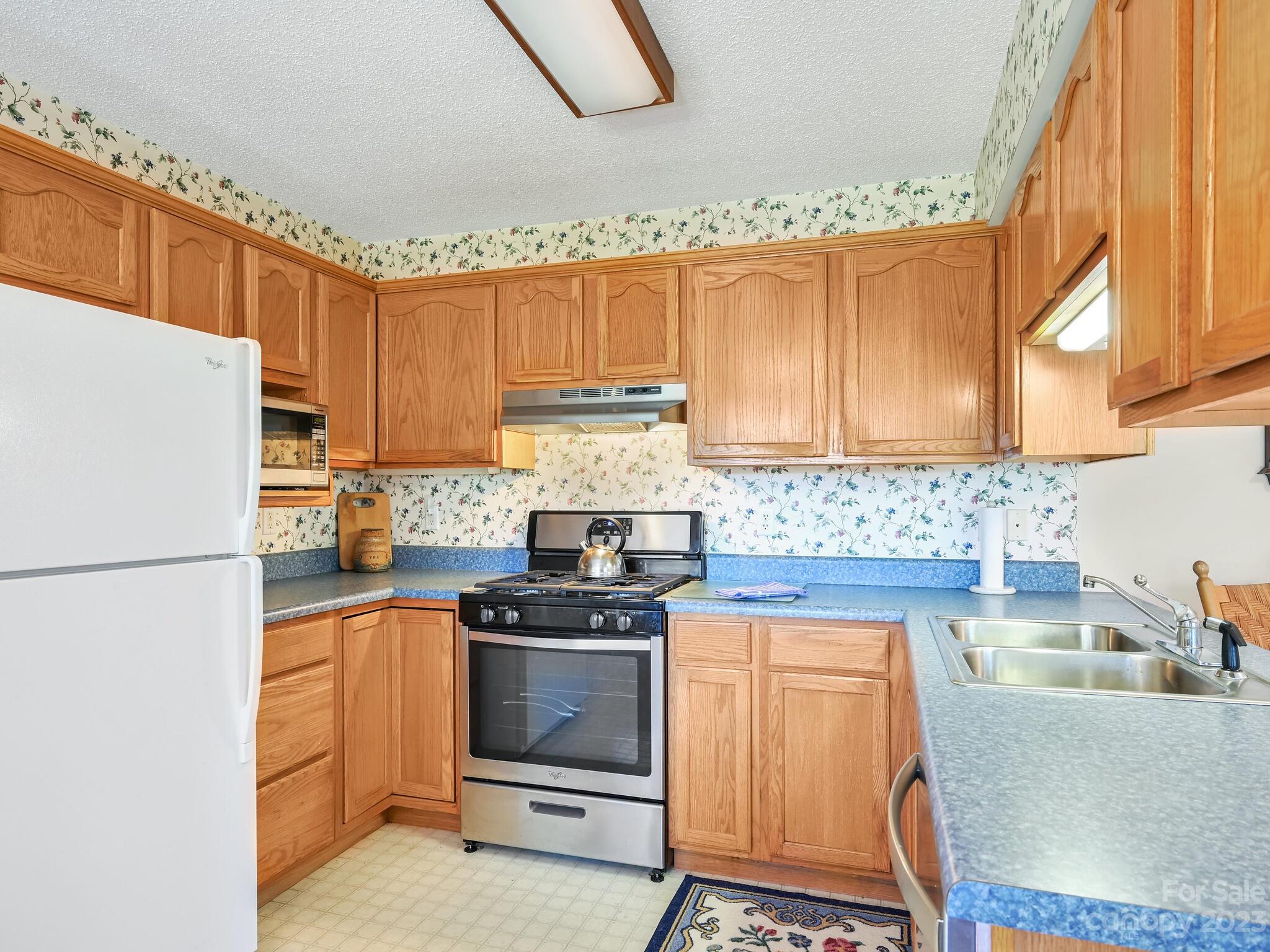 15 Maple Road Arden, NC 28704 - Photo 11 of 33 a kitchen with a stove a sink and a refrigerator