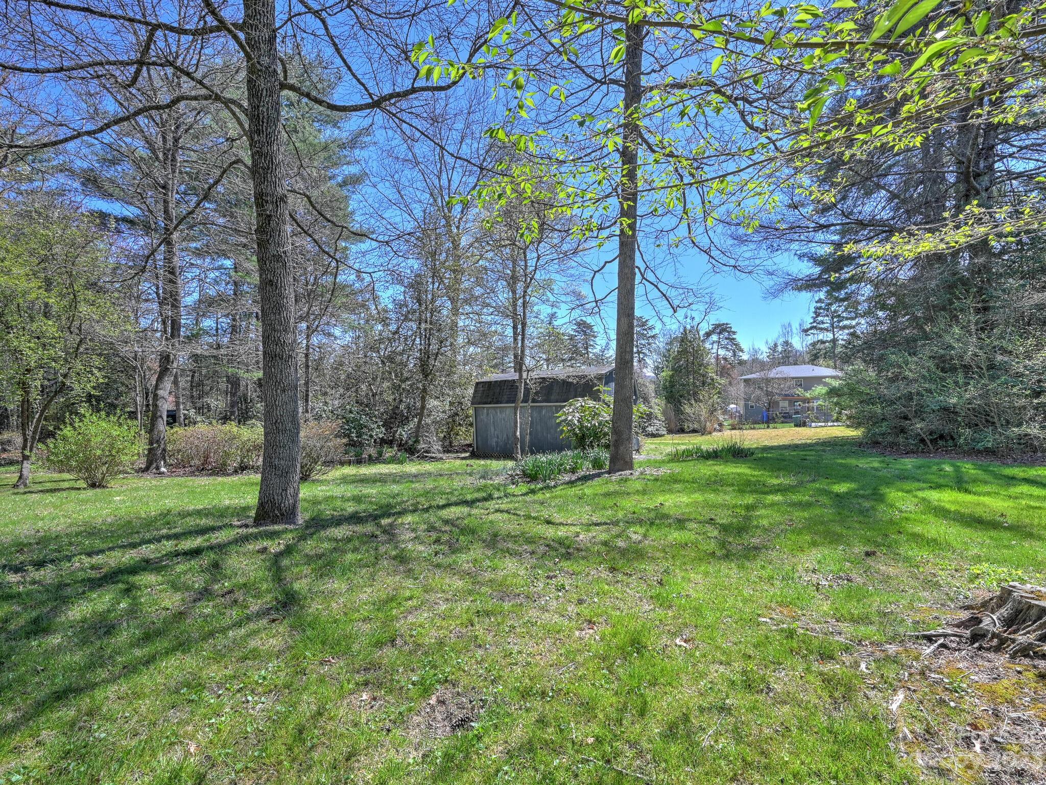 15 Maple Road Arden, NC 28704 - Photo 28 of 33 a backyard of a house with plants and large trees