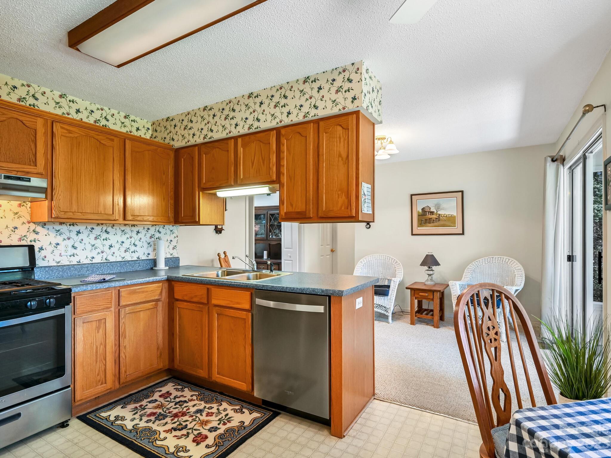15 Maple Road Arden, NC 28704 - Photo 9 of 33 a kitchen with stainless steel appliances a stove a sink dishwasher and cabinets with wooden floor