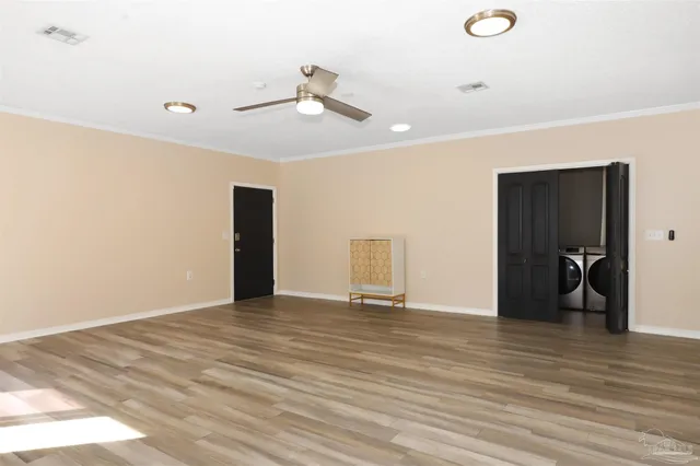 a view of an empty room with wooden floor