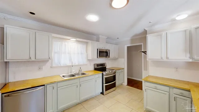 a kitchen with granite countertop a sink stainless steel appliances and cabinets