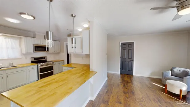 a large kitchen with cabinets wooden floor and stainless steel appliances