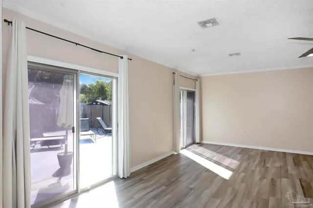 a view of a hallway with wooden floor and a bathroom