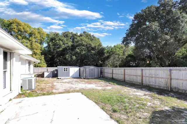 a view of backyard with swimming pool and furniture