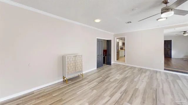 a view of an empty room with closet and a window