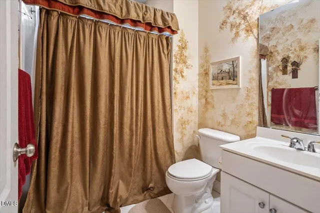 a bathroom with a sink a toilet and shower curtain