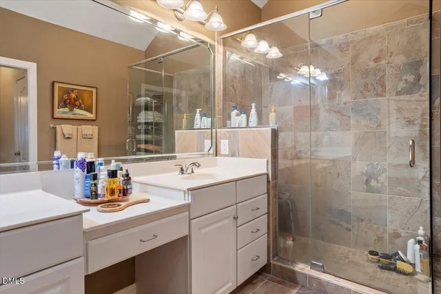 a bathroom with a sink shower and a mirror