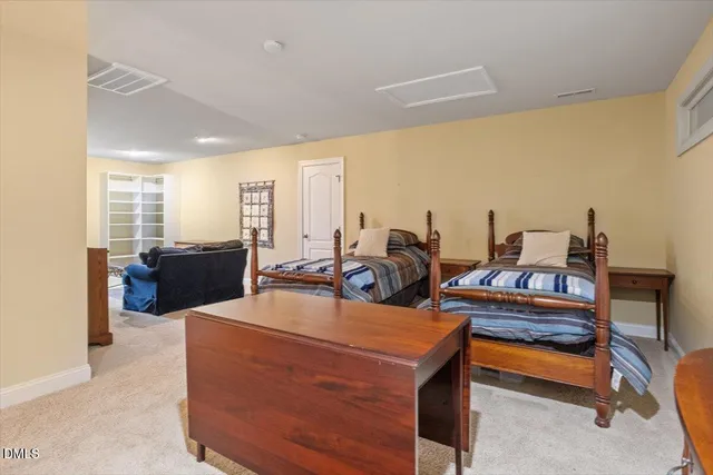 a living room with chairs kitchen view and a large window