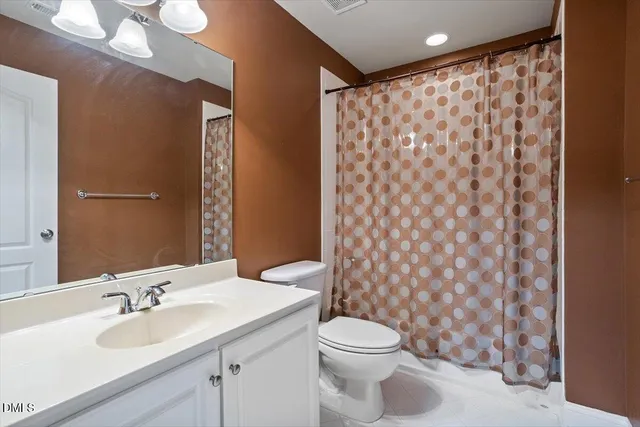 a bathroom with a sink a toilet and shower curtain