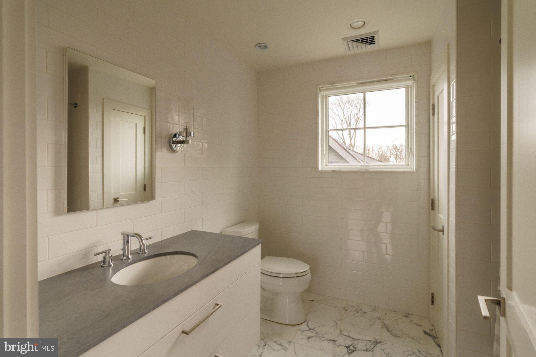 609 St Andrews Road Philadelphia, PA 19118 - Photo 32 of 43 a bathroom with a granite countertop sink a toilet and a mirror