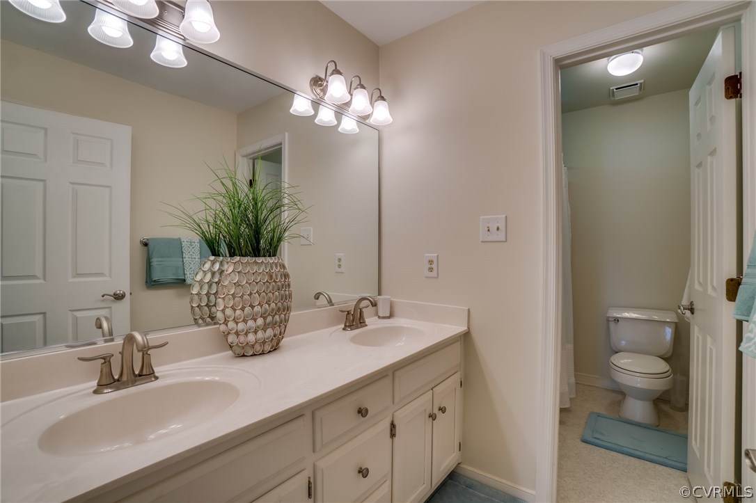15209 Windy Ridge Road Midlothian, VA 23112 - Photo 27 of 40 a bathroom with a toilet a sink and a large mirror