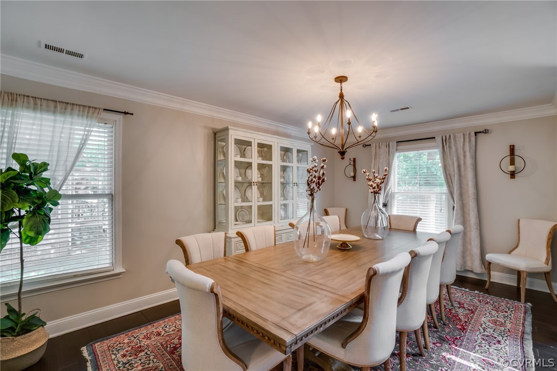 15209 Windy Ridge Road Midlothian, VA 23112 - Photo 8 of 40 a dining room with wooden floor a chandelier a wooden table and chairs