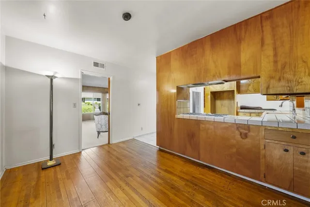 a view of a refrigerator a sink and cabinets