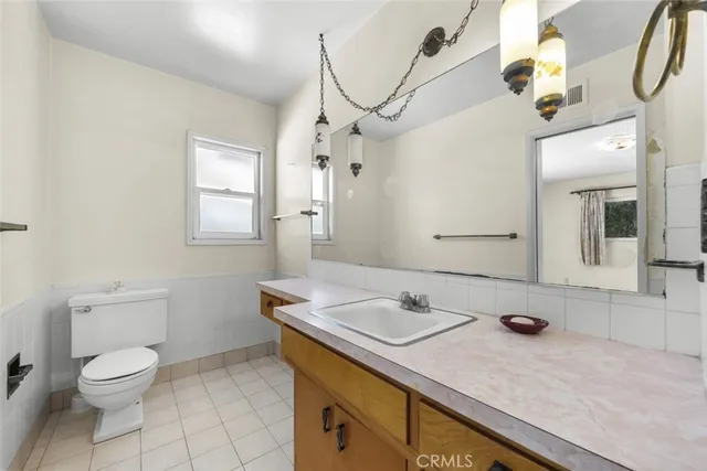 a bathroom with a sink vanity granite and toilet