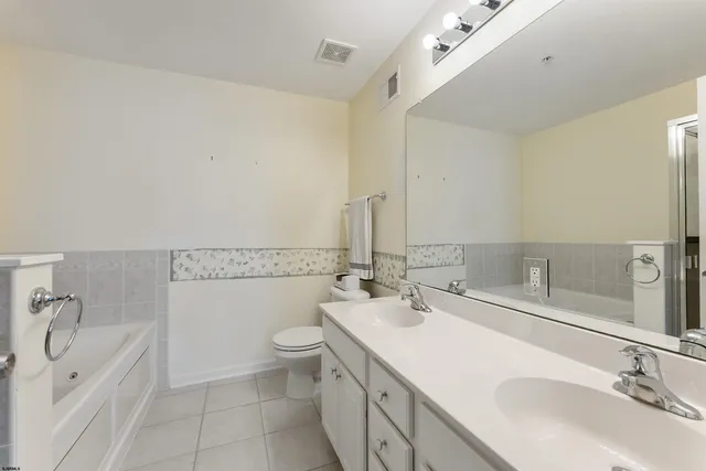 a bathroom with a double vanity sink mirror and toilet