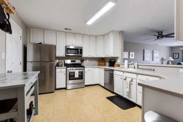 a kitchen with a sink white cabinets and stainless steel appliances