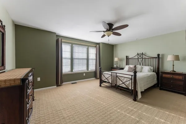 a spacious bedroom with a bed and a chandelier