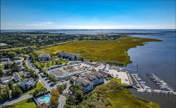 an aerial view of ocean and residential houses with outdoor space