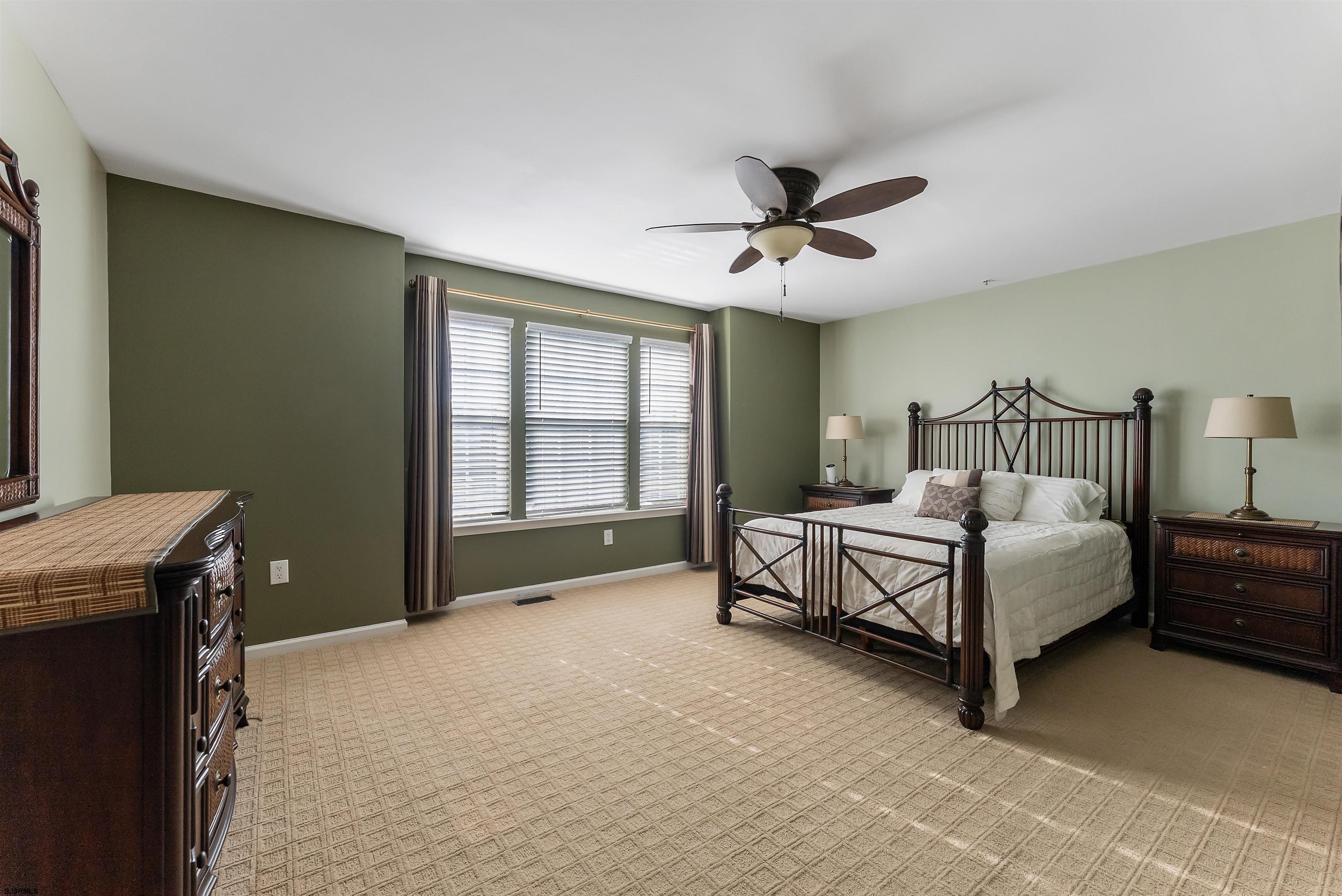 3 Bayside Drive, Unit 3 Somers Point, NJ 08244 - Photo 10 of 30 a spacious bedroom with a bed and a chandelier