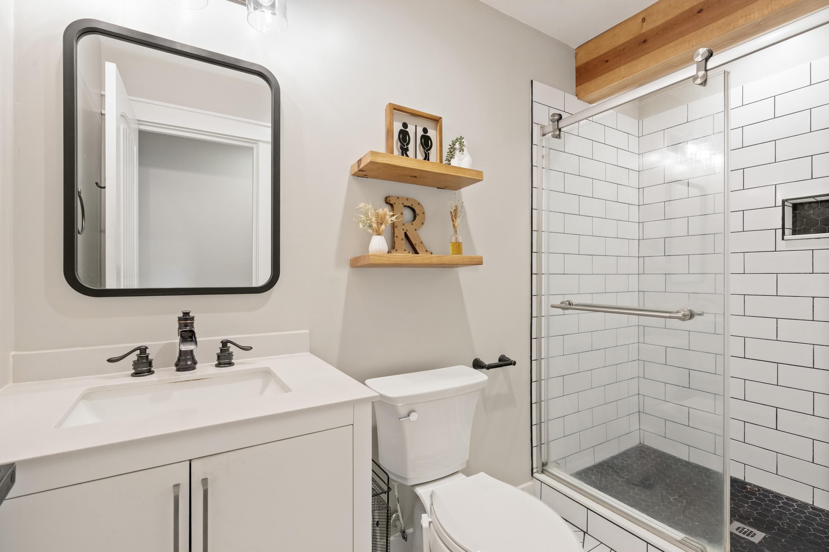 4370 Given Avenue Memphis, TN 38122 - Photo 12 of 30 Glass-enclosed shower with white subway tile surround and dark hexagonal tile flooring