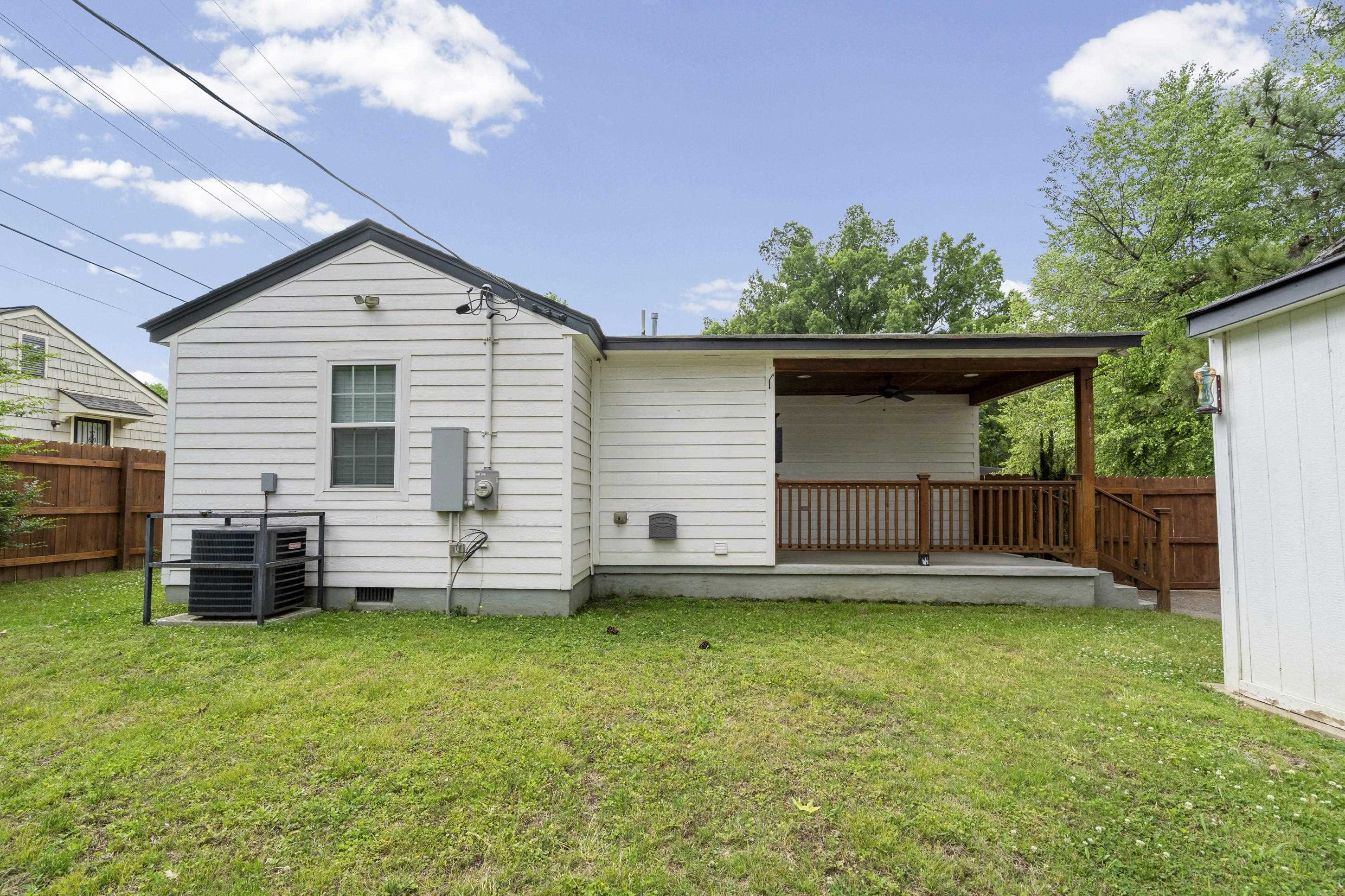 4370 Given Avenue Memphis, TN 38122 - Photo 26 of 30 Expansive backyard featuring a covered patio with wood railing and ceiling fan, white siding exterior, and a detached storage shed