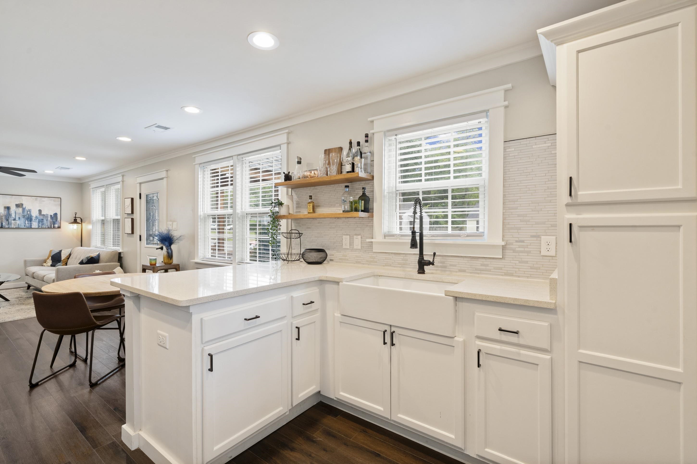4370 Given Avenue Memphis, TN 38122 - Photo 4 of 30 Modern kitchen featuring white shaker-style cabinetry, a white farmhouse sink with a matte black faucet, and light-toned countertops
