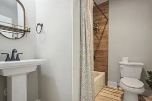 a bathroom with a sink a toilet and a mirror