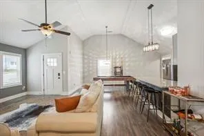 a living room with furniture a chandelier and wooden floor