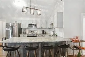 a kitchen with granite countertop a table chairs stove and cabinets