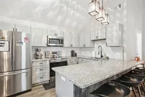 a kitchen with stainless steel appliances granite countertop a sink stove and refrigerator