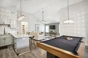 a kitchen with stainless steel appliances granite countertop a sink dishwasher a stove a dining table and chairs with wooden floor