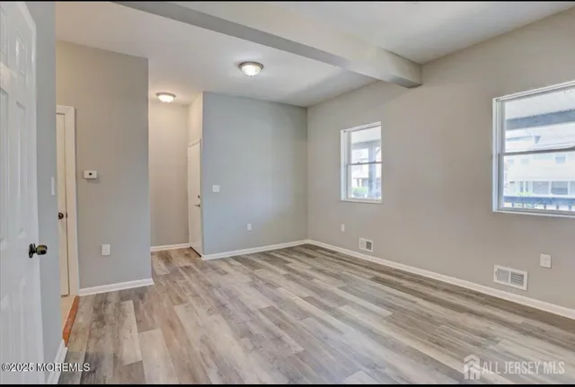 an empty room with windows and closet