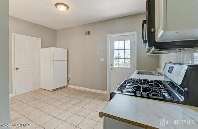 a white stove top oven sitting inside of a kitchen